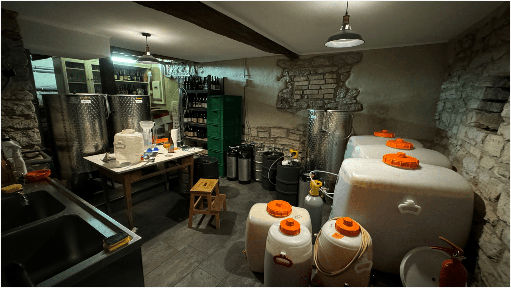 A cellar filled with plastic and steel tanks of various sizes